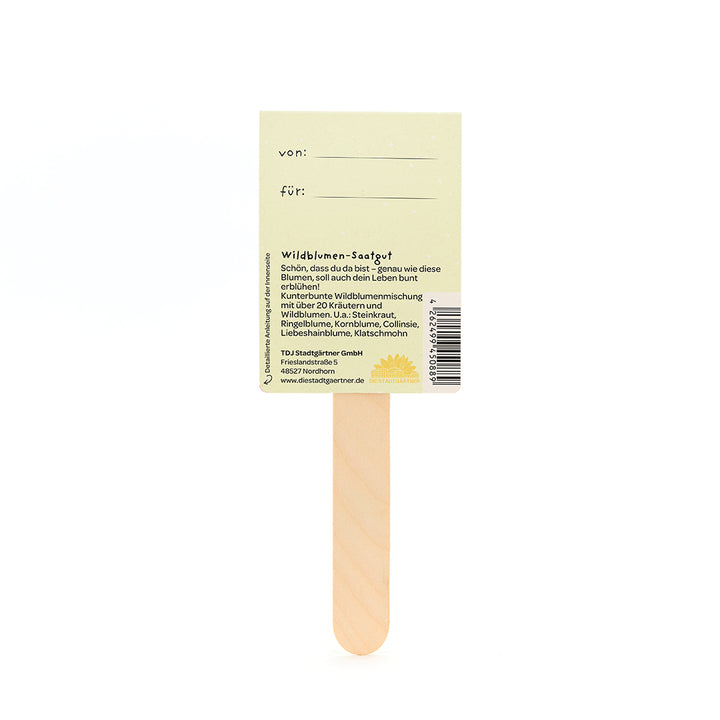 Rückseite eines Wildblumen-Saatgut-Sticks aus Holz mit gelbem Etikett und deutscher Beschreibung.
