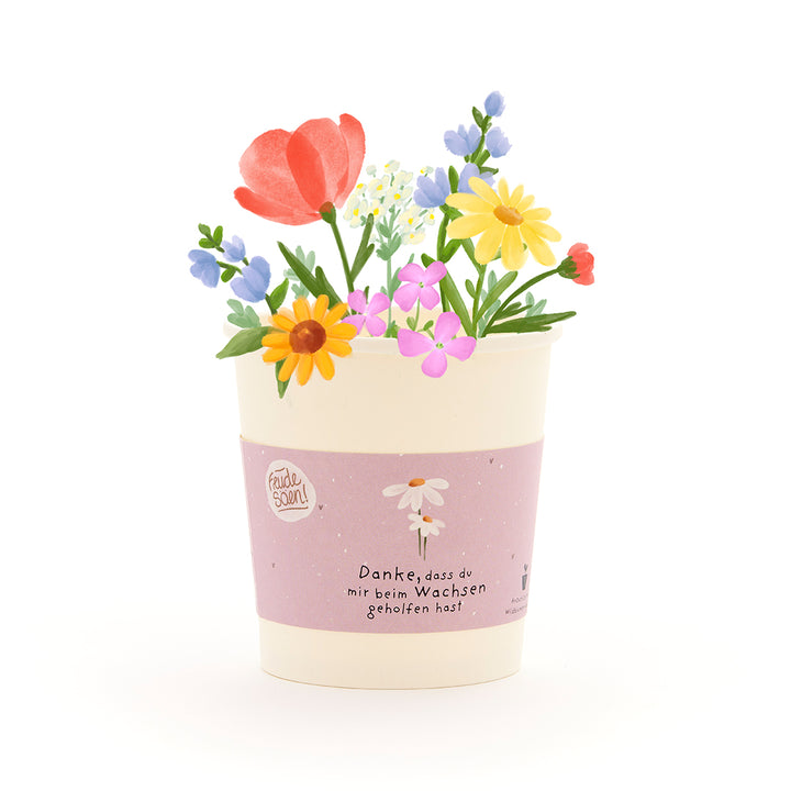 Ein Blumentopf mit bunten, gezeichneten Blumen und einer Banderole, auf der steht: "Danke, dass du mir beim Wachsen geholfen hast."